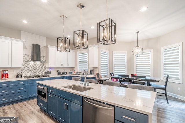 5490 Bent Grass Way, Douglasville, GA 30135 - kitchen with wall chimney range hood, appliances with stainless steel finishes, a sink, blue cabinets, and white cabinets
