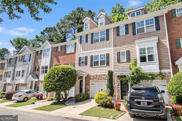 3068 Lauren Parc Rd, Decatur, GA 30032 - townhome / multi-family property featuring stone siding, an attached garage, board and batten siding, and driveway