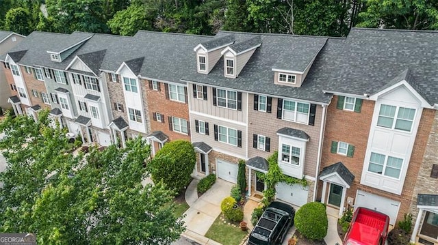 3068 Lauren Parc Rd, Decatur, GA 30032 - view of front facade with a garage, concrete driveway, brick siding, board and batten siding, and view of scattered trees