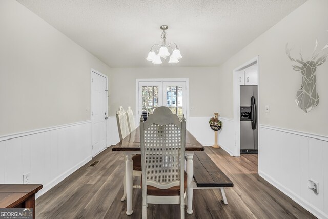 933 Chisholm Trl, Macon, GA 31220 - dining area featuring a chandelier, a wainscoted wall, dark wood-style floors, a textured ceiling, and french doors