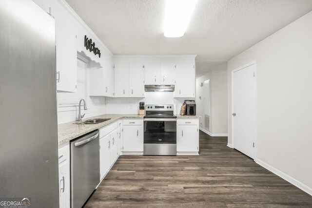 933 Chisholm Trl, Macon, GA 31220 - kitchen featuring stainless steel appliances, under cabinet range hood, a textured ceiling, white cabinetry, and dark wood finished floors