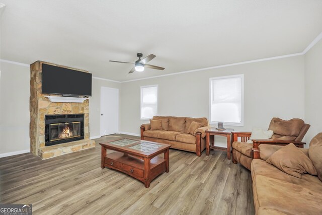 933 Chisholm Trl, Macon, GA 31220 - living area with a ceiling fan, light wood-style floors, a stone fireplace, and ornamental molding