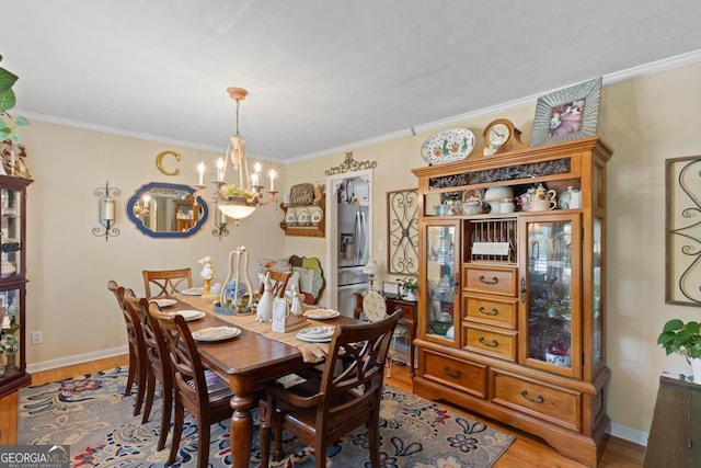 118 Duvall Dr, Stockbridge, GA 30281 - dining space with light wood finished floors, a chandelier, and crown molding