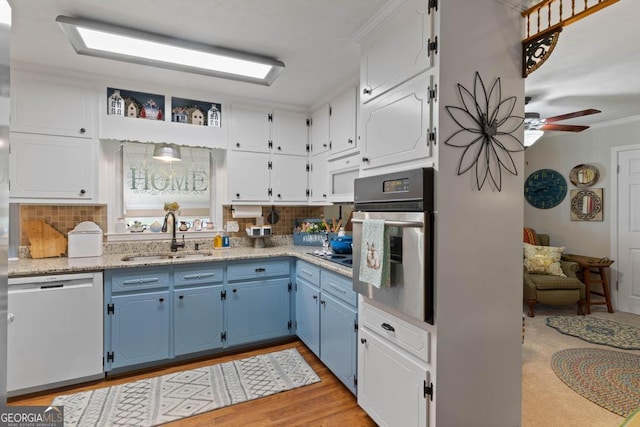 118 Duvall Dr, Stockbridge, GA 30281 - kitchen with stainless steel oven, dishwashing machine, blue cabinetry, decorative backsplash, and crown molding