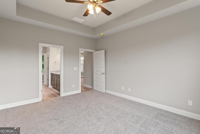 123 Oak Rd, Locust Grove, GA 30248 - unfurnished bedroom featuring light colored carpet, baseboards, a tray ceiling, and ensuite bathroom