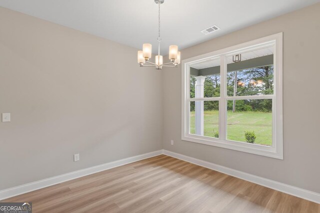 123 Oak Rd, Locust Grove, GA 30248 - empty room featuring baseboards, a chandelier, light wood-type flooring, and healthy amount of natural light