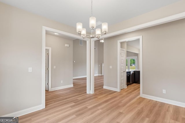 123 Oak Rd, Locust Grove, GA 30248 - spare room featuring a chandelier, light wood-style flooring, and baseboards