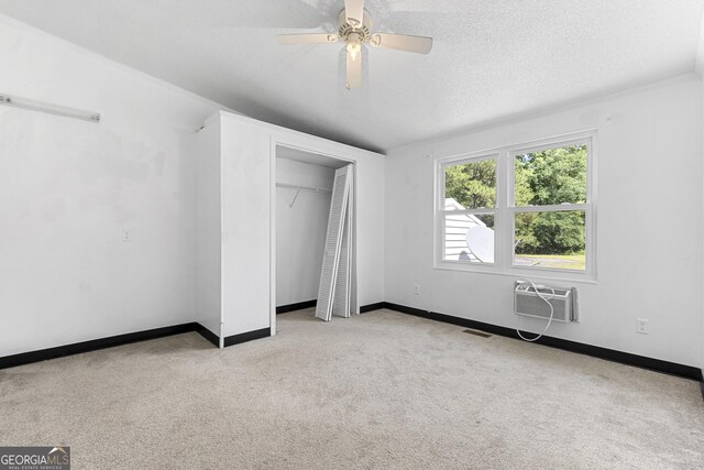 256 Battlefield Dr, Macon, GA 31217 - unfurnished bedroom featuring an AC wall unit, carpet flooring, baseboards, a closet, and a textured ceiling