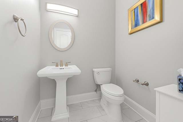 3280 Stillhouse Ln SE Unit 410, Atlanta, GA 30339 - bathroom featuring marble look tiles, toilet, baseboards, and a sink