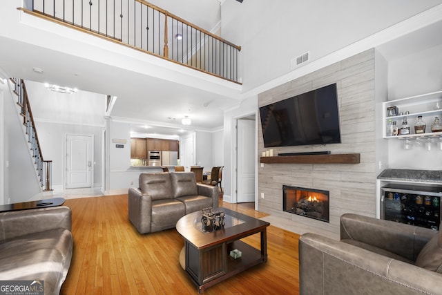 3280 Stillhouse Ln SE Unit 410, Atlanta, GA 30339 - living area featuring light wood-style floors, ornamental molding, a tiled fireplace, a high ceiling, and stairway