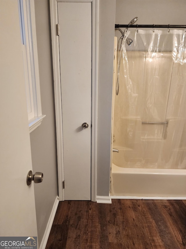1751 Brindle Ln, Macon, GA 31220 - full bathroom featuring wood finished floors, shower / bath combo with shower curtain, and baseboards