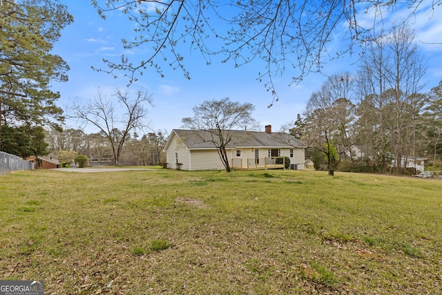 1312 Milstead Ave NE, Conyers, GA 30012 - rear view of house featuring a lawn, a chimney, and a deck