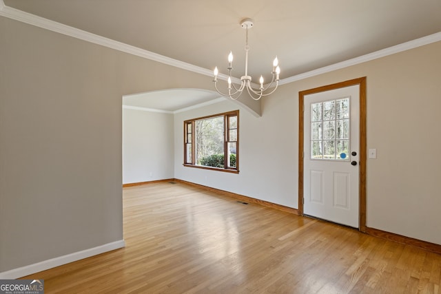1312 Milstead Ave NE, Conyers, GA 30012 - foyer with a chandelier, light wood-style floors, ornamental molding, and arched walkways