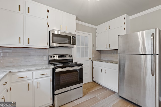 1312 Milstead Ave NE, Conyers, GA 30012 - kitchen featuring stainless steel appliances, crown molding, white cabinetry, wood tiled floors, and tasteful backsplash