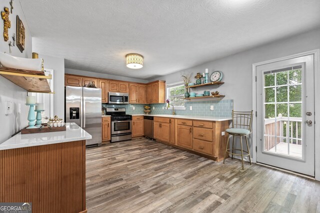 2009 Parador Aly, Mcdonough, GA 30253 - kitchen with appliances with stainless steel finishes, light wood-style floors, light countertops, tasteful backsplash, and a sink