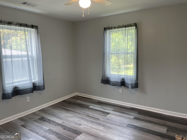 3433 Sandra Fay Dr, Macon, GA 31206 - empty room featuring healthy amount of natural light, a ceiling fan, dark wood finished floors, and baseboards