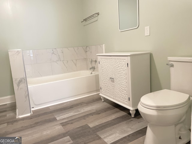 3433 Sandra Fay Dr, Macon, GA 31206 - bathroom with toilet, a bath, wood finished floors, vanity, and baseboards