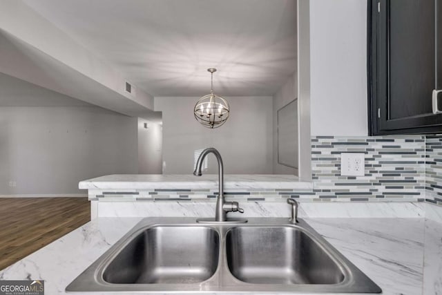 2135 N Forest Trl, Atlanta, GA 30338 - kitchen with decorative backsplash, light stone countertops, wood finished floors, hanging light fixtures, and a chandelier