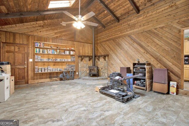 4845 Willow St, Acworth, GA 30101 - living room with wooden walls, a wood stove, ceiling fan, a wooden ceiling with exposed beams, and high vaulted ceiling