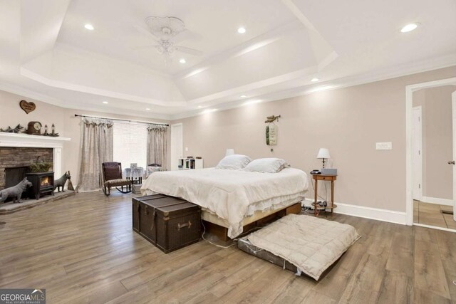 4845 Willow St, Acworth, GA 30101 - bedroom featuring a raised ceiling, wood finished floors, recessed lighting, a stone fireplace, and ornamental molding