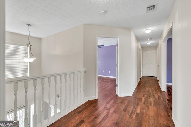 3338 Gardenside Walk, Loganville, GA 30052 - corridor featuring a textured ceiling, wood finished floors, and an upstairs landing
