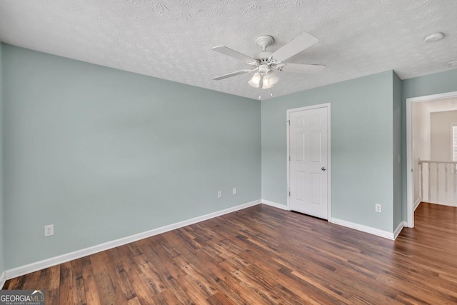 3338 Gardenside Walk, Loganville, GA 30052 - unfurnished bedroom with dark wood-style flooring, a textured ceiling, and a ceiling fan