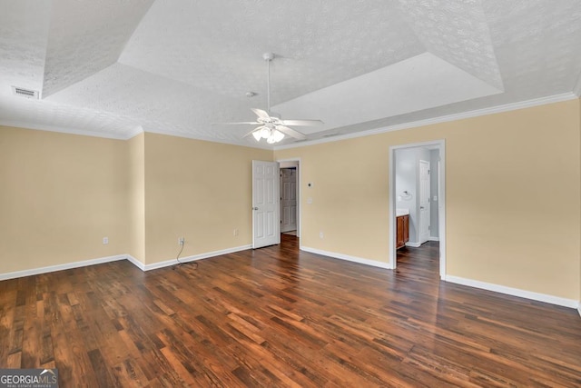 3338 Gardenside Walk, Loganville, GA 30052 - empty room featuring a tray ceiling, dark wood-type flooring, crown molding, and a textured ceiling