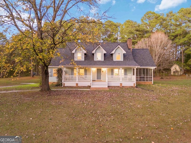 935 Old Loganville Rd, Loganville, GA 30052 - new england style home featuring a chimney, a front yard, a porch, and a sunroom