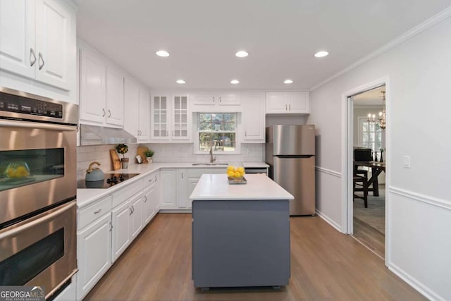 935 Old Loganville Rd, Loganville, GA 30052 - kitchen featuring appliances with stainless steel finishes, backsplash, light wood-type flooring, plenty of natural light, and crown molding