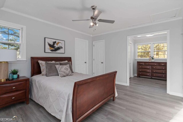 935 Old Loganville Rd, Loganville, GA 30052 - bedroom with wood finished floors, multiple windows, ornamental molding, a ceiling fan, and attic access
