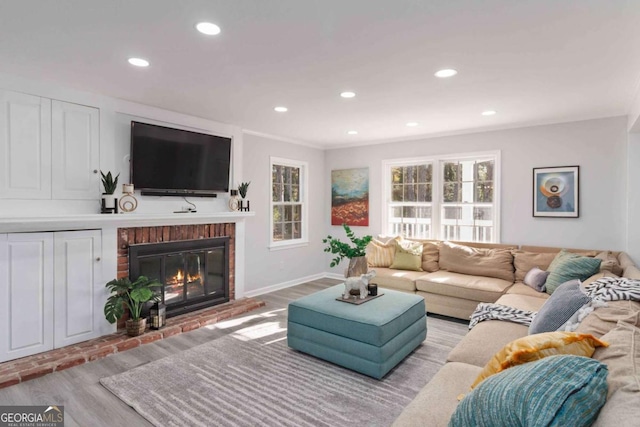 935 Old Loganville Rd, Loganville, GA 30052 - living area with wood finished floors, healthy amount of natural light, a brick fireplace, recessed lighting, and crown molding