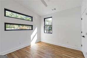 1464 Ezra Church Dr NW, Atlanta, GA 30314 - spare room featuring lofted ceiling, baseboards, and wood finished floors