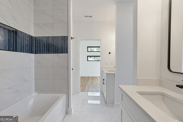 1464 Ezra Church Dr NW, Atlanta, GA 30314 - bathroom featuring two vanities, a bath, marble finish floors, and baseboards