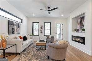 1464 Ezra Church Dr NW, Atlanta, GA 30314 - living area featuring a glass covered fireplace, a ceiling fan, wood finished floors, and recessed lighting