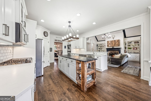 206 Savanna Estates Ct, Canton, GA 30115 - kitchen with a chandelier, ornamental molding, a fireplace, appliances with stainless steel finishes, and white cabinetry