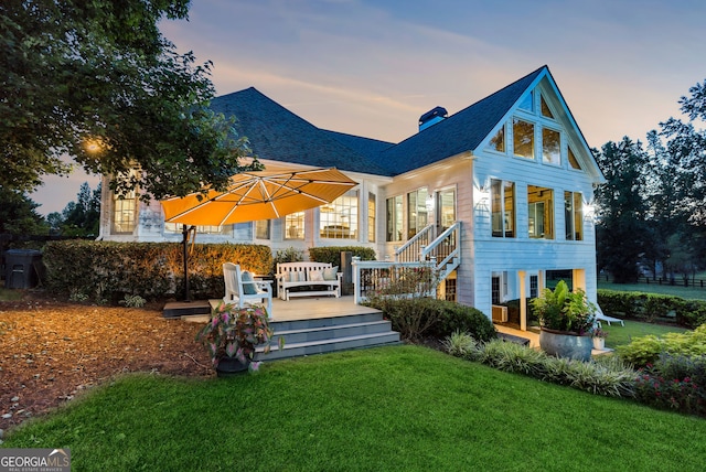 206 Savanna Estates Ct, Canton, GA 30115 - back of house at dusk featuring a yard, a chimney, a deck, and roof with shingles