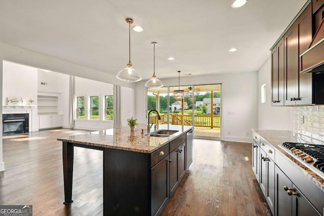 847 Rolling Hl, Kennesaw, GA 30152 - kitchen with a sink, a fireplace with flush hearth, appliances with stainless steel finishes, light stone countertops, and dark wood-type flooring