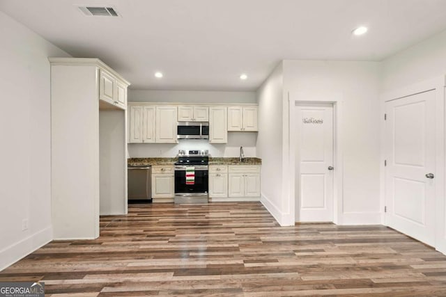 847 Rolling Hl, Kennesaw, GA 30152 - kitchen featuring appliances with stainless steel finishes, a sink, recessed lighting, wood finished floors, and stone counters