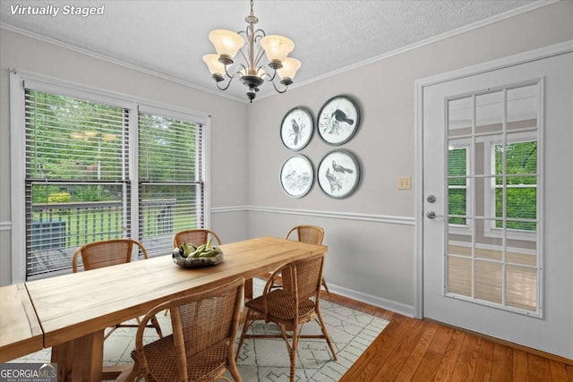 1267 Austin Bridge Rd, Douglasville, GA 30134 - dining space featuring a chandelier, hardwood / wood-style floors, crown molding, and a textured ceiling