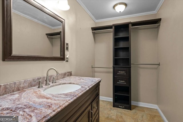 1267 Austin Bridge Rd, Douglasville, GA 30134 - bathroom with vanity, ornamental molding, stone finish floors, and a walk in closet