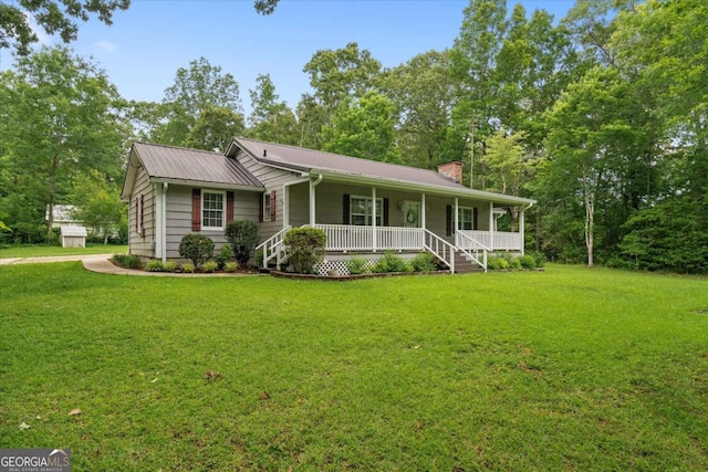 1267 Austin Bridge Rd, Douglasville, GA 30134 - view of front facade with covered porch, a chimney, a front lawn, and a metal roof