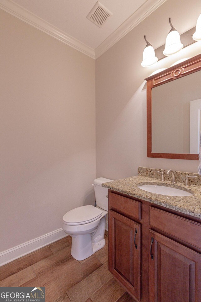 319 Beaconsfield Dr, Sharpsburg, GA 30277 - bathroom featuring crown molding, wood finished floors, toilet, vanity, and baseboards