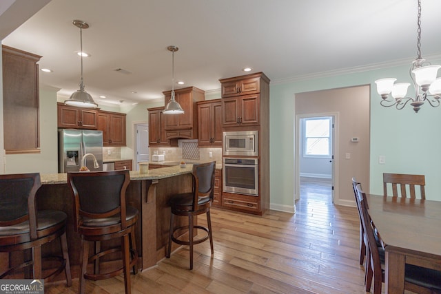 319 Beaconsfield Dr, Sharpsburg, GA 30277 - kitchen with stainless steel appliances, decorative backsplash, a breakfast bar area, light stone counters, and a chandelier