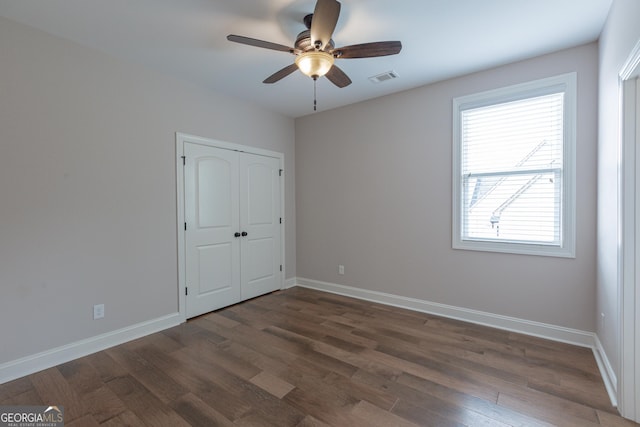 319 Beaconsfield Dr, Sharpsburg, GA 30277 - unfurnished bedroom with dark wood-style flooring, baseboards, a closet, and a ceiling fan