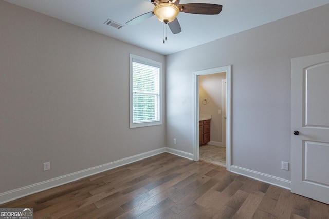 319 Beaconsfield Dr, Sharpsburg, GA 30277 - unfurnished bedroom featuring wood finished floors, baseboards, ensuite bathroom, and a ceiling fan