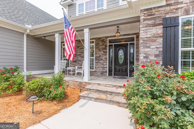 319 Beaconsfield Dr, Sharpsburg, GA 30277 - property entrance featuring stone siding, covered porch, and a shingled roof