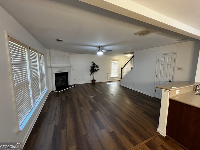 3613 Tinsley Way, Atlanta, GA 30331 - unfurnished living room featuring stairs, dark wood-style flooring, a fireplace with raised hearth, and ceiling fan
