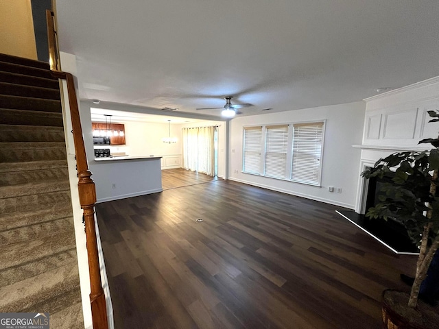 3613 Tinsley Way, Atlanta, GA 30331 - unfurnished living room featuring a ceiling fan, dark wood-type flooring, stairway, a fireplace with raised hearth, and a chandelier