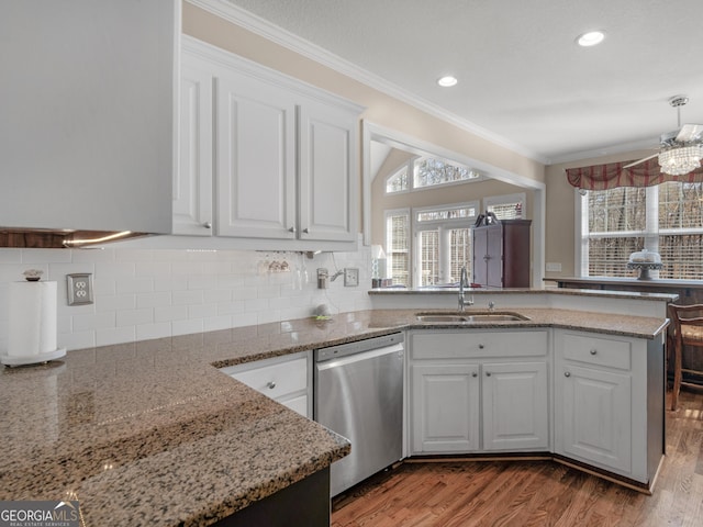 355 Parker Rd, Covington, GA 30014 - kitchen with stainless steel dishwasher, white cabinets, a peninsula, crown molding, and backsplash