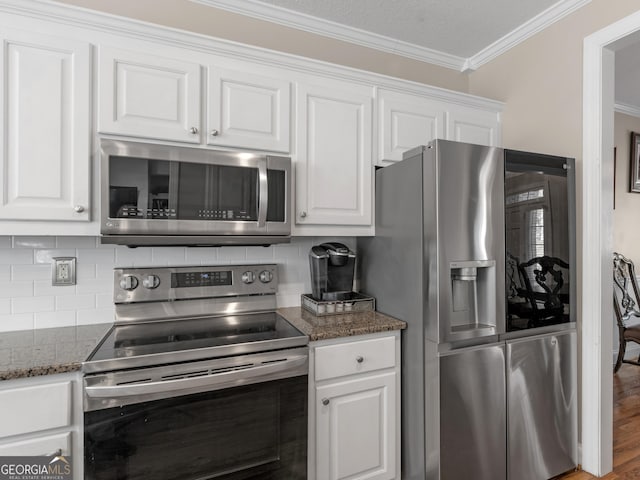 355 Parker Rd, Covington, GA 30014 - kitchen with stainless steel appliances, crown molding, white cabinets, decorative backsplash, and dark stone counters